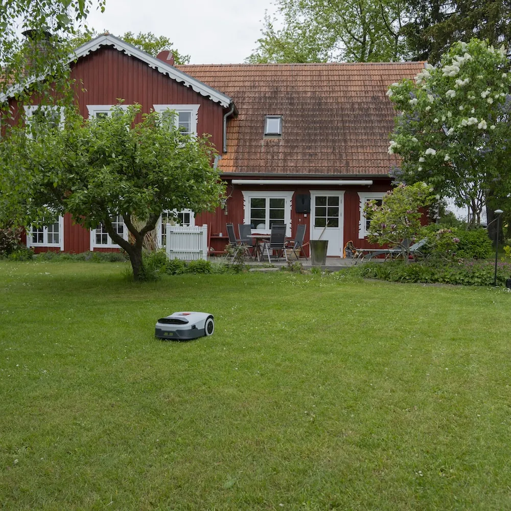 Mähroboter Anthbot Genie vor rotem Landhaus